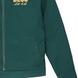 Chaqueta DEUS EX MACHINA Cutaway Racing Green — detalle del bordado frontal y bolsillo