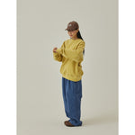 Sudadera KAPPY Pigment Sweatshirt Mustard, vista lateral sobre modelo
