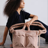 ÖLEND Rain Ona Dust Pink en rosa empolvado, con modelo sentada y bolso sobre las piernas