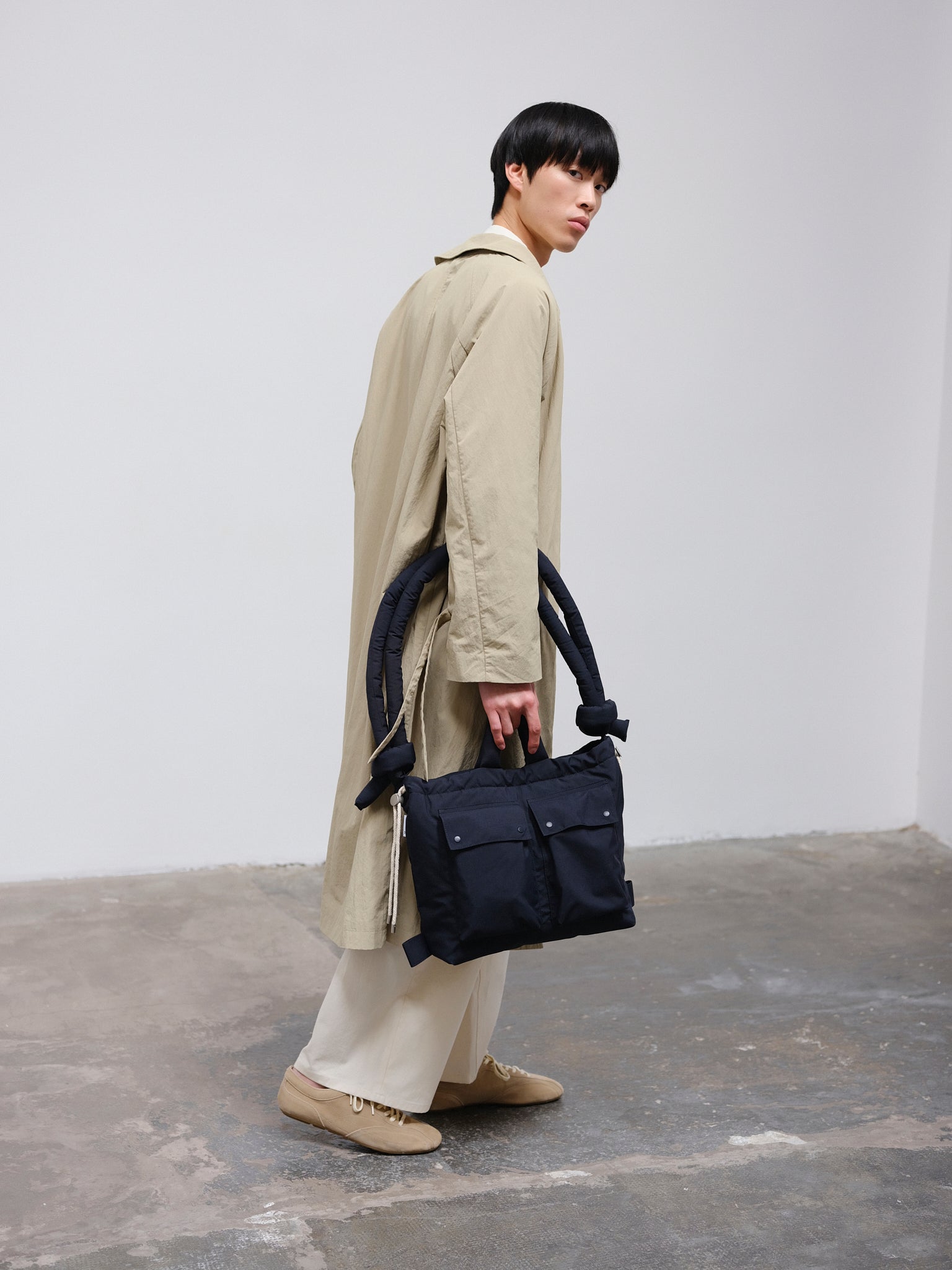 ÖLEND Rain Ona Navy en azul marino, con modelo, llevado por el asa de mano