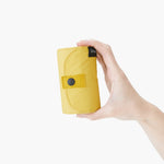 Bolsa SHUPATTO Compact L 40 L Mustard plegada en la mano