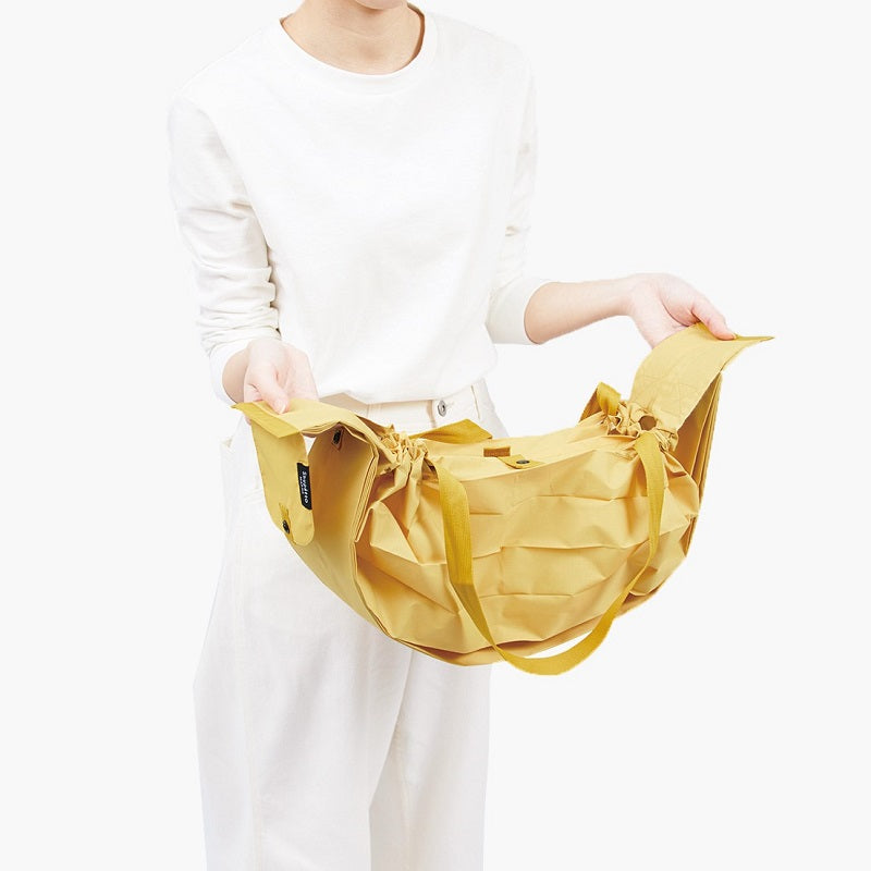 Bolsa SHUPATTO Compact L 40 L Mustard, primer paso de plegado
