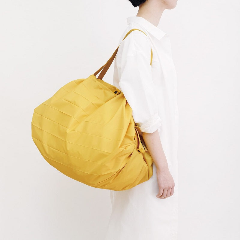 Bolsa SHUPATTO Compact L 40 L Mustard llevada por modelo